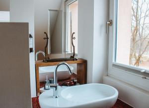 ein Badezimmer mit Waschbecken und Spiegel in der Unterkunft Hotel Palmenbad in Kassel + 48 Fotos