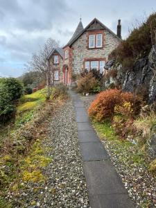 a stone house with a path leading to it at Dunivaig B&B in Tarbert