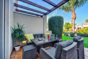 a patio with wicker chairs and a table on a patio at Villa Magnolia The Crest 3 quartos e piscina in Almancil