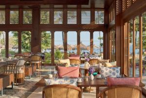 a restaurant with tables and chairs and windows at Paradisus by Meliá Bali in Nusa Dua