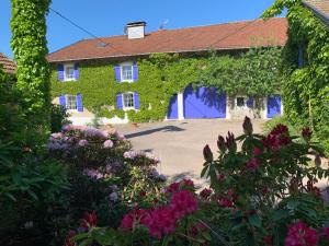 a house covered in ivy with a bunch of flowers at La Ferme de Mehachamp in Remiremont