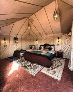 a bedroom with two beds in a tent at Luxury Suerte Camp in Merzouga