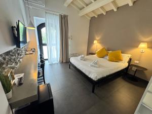 a bedroom with a bed with yellow pillows at Talè Restaurant & Suite in Piedimonte Etneo +145 photos