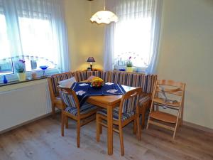 a dining room with a table and chairs and windows at Ferienhaus Soonwald in Schwarzerden