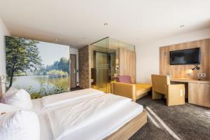 a hotel room with two beds and a large window at Hotel Salinensee in Bad Dürrheim