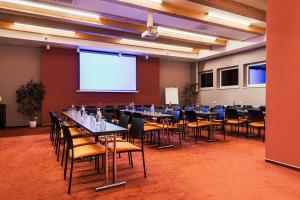 ein Konferenzraum mit Tischen und Stühlen sowie einer Projektionsfläche in der Unterkunft Hotel Helios in Lipová-lázně + 190 Fotos