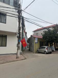 a street with a red flag on a pole with a car at Nhà nghỉ thảo chung in Kỳ Lừa