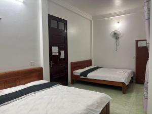 a bedroom with two beds and a door in it at Nhà nghỉ thảo chung in Kỳ Lừa +5 photos
