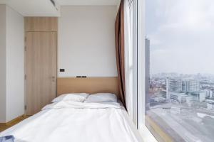 a bed in a room with a large window at Siamese Residence Sukhumvit 42 Bangkok in Bangkok