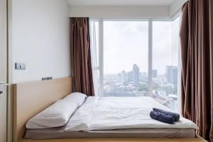 a bed in a room with a large window at Siamese Residence Sukhumvit 42 Bangkok in Bangkok
