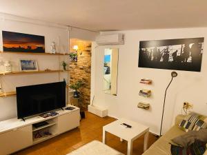a living room with a flat screen tv on a wall at Ático Cádiz Suite in Cádiz
