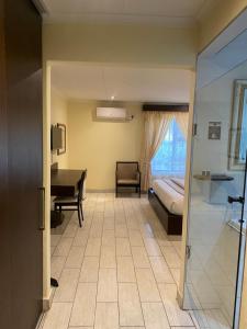 a hotel room with a bedroom and a bed and a desk at Villa Via Hotel Midrand in Midrand +23 photos