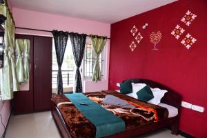 a bedroom with a red wall and a bed at FFF Cottage in Ooty