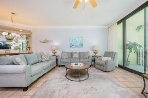 a living room with two couches and a table at Phoenix on the Bay 1122 condo in Orange Beach