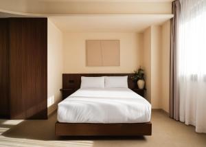 a bedroom with a white bed and a window at Limehome Bilbao Juan Antonio Zunzunegui in Bilbao