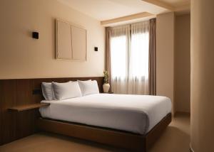 a bedroom with a large white bed with a window at Limehome Bilbao Juan Antonio Zunzunegui in Bilbao +42 photos