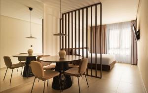 a bedroom with two tables and chairs and a bed at Limehome Bilbao Juan Antonio Zunzunegui in Bilbao