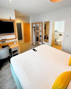 a large bedroom with a large white bed and a desk at Haslar Rooms in Gosport +8 photos