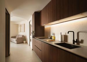 a kitchen with wooden cabinets and a sink and a couch at Limehome Bilbao Juan Antonio Zunzunegui in Bilbao
