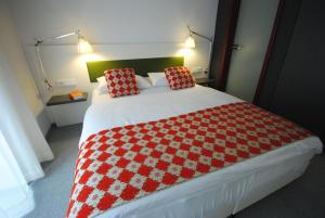 a hotel room with a red and white checkered bed at DASKöln in Cologne