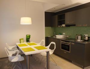 a kitchen with a table and white chairs in a kitchen at DASKöln in Cologne