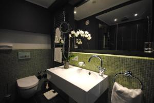 a bathroom with a sink and a toilet and a mirror at DASKöln in Cologne