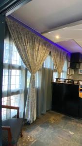 a room with a window with curtains and a table at Villa Via Hotel Midrand in Midrand