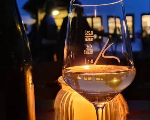 a glass of wine sitting next to a bottle of wine at Landhotel Kachelofa in Vaihingen an der Enz