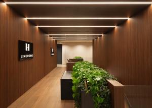a hallway with a lobby with plants in a building at Limehome Bilbao Juan Antonio Zunzunegui in Bilbao