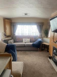 a living room with a couch and a window at KC Caravans in Ingoldmells