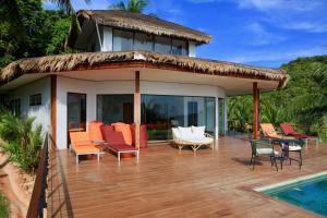 a wooden deck with chairs and a house at House of Rising Sun in Thong Nai Pan Noi