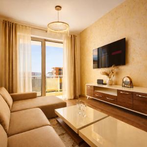a living room with a couch and a tv at NUR Apartment in Dobra Voda