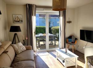 a living room with a couch and a table at Villa Chez Laurette - Baie de Somme en famille - 4 à 6 personnes - piscine - parking privé - plage à 5 min in Le Crotoy