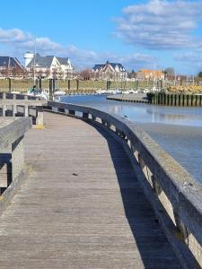 a wooden bridge over a body of water at Villa Chez Laurette - Baie de Somme en famille - 4 à 6 personnes - piscine - parking privé - plage à 5 min in Le Crotoy +3 photos