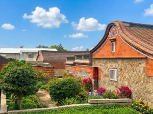 an old brick building with flowers in a garden at Zhong Lan Homestay in Chung-lan