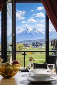 a table with a view of mountains from a window at Góralski Resort Family & SPA in Białka Tatrzańska +253 photos