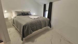 a bedroom with a bed in a white room at Stopa Art Residence in Šempeter pri Gorici