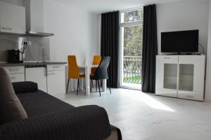 a living room with a kitchen and a table with chairs at Stopa Art Residence in Šempeter pri Gorici +52 photos