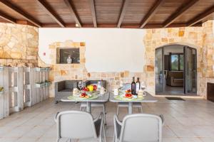 a patio with a table and chairs and a fireplace at Trulli degli Augelli by BarbarHouse in San Michele Salentino