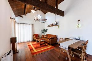a living room with a table and a couch at Villa Ferme Yatsugatake in Hokuto