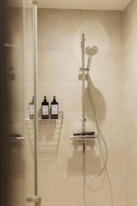 a shower in a bathroom with two bottles on a wall at HYGGE HOMES - Apartment 'silva' in Winsen +76 photos