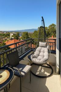 a porch with two chairs and a swing on a balcony at Panorama GOLD Vrnjačka Banja in Vrnjačka Banja