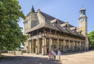 a group of people walking in front of a building with a clock tower at glamour chic maison de 70 m2 in Montluçon