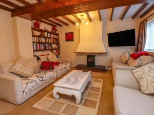 a living room with two couches and a tv at The Old Stables in Colwyn Bay