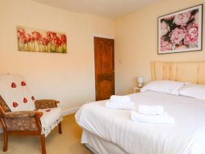 a bedroom with two beds and a chair in it at The Old Stables in Colwyn Bay