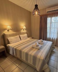 a bedroom with a large bed with towels on it at Fenareti Apartments in Skala Eresou
