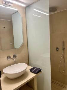 a bathroom with a white sink and a shower at Fenareti Apartments in Skala Eresou