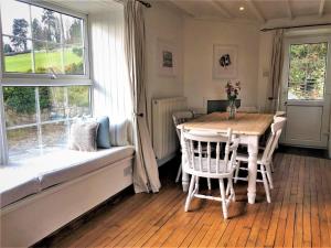 a dining room with a table and chairs and a window at 3 Bed in Conwy oc-typll in Llangelynin