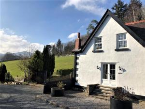 a white house with a field in the background at 3 Bed in Conwy oc-typll in Llangelynin
