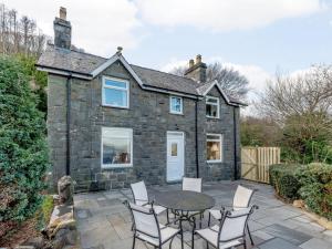 an exterior view of a stone house with a table and chairs at 3 Bed in Conwy oc-85844 in Llanbedr-y-cennin